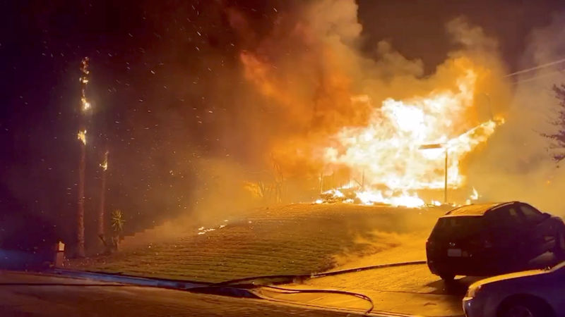 © Reuters. A house burns during wildfires in San Bernardino, California