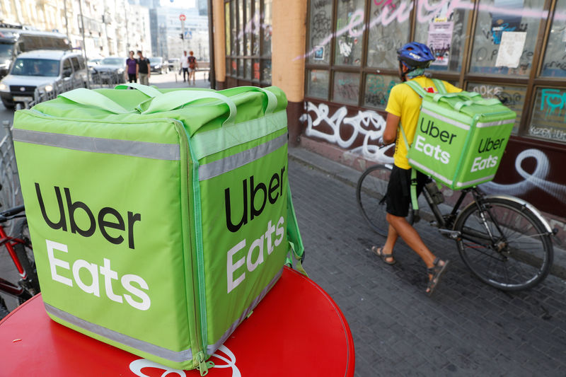 © Reuters. An Uber Eats courier walks in Kiev
