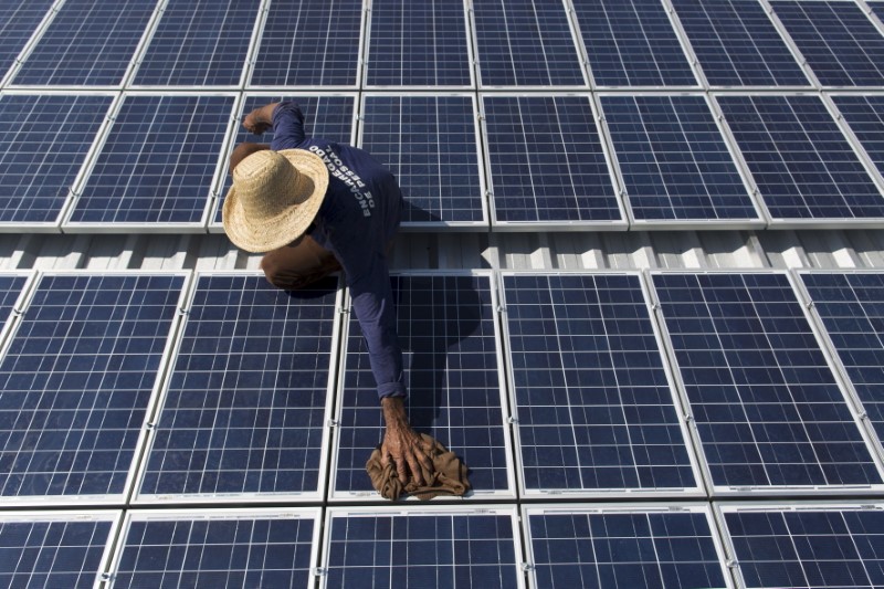 © Reuters. Homem checa painéis de energia solar em Vila Nova do Amanã (AM)