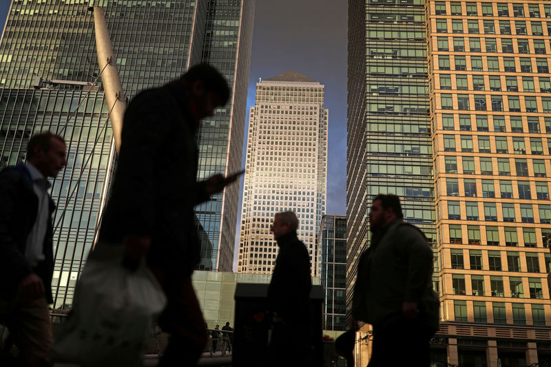 © Reuters. FILE PHOTO: People walk through the Canary Wharf financial district of London