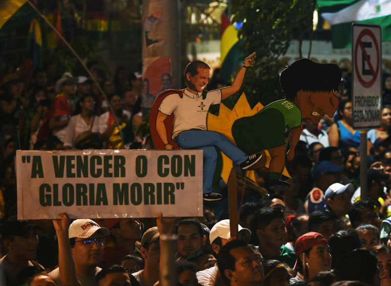 © Reuters. Manifestantes erguem cartaz representando Luis Fernando Camacho e Evo Morales durante protesto em Santa Cruz, na Bolícia