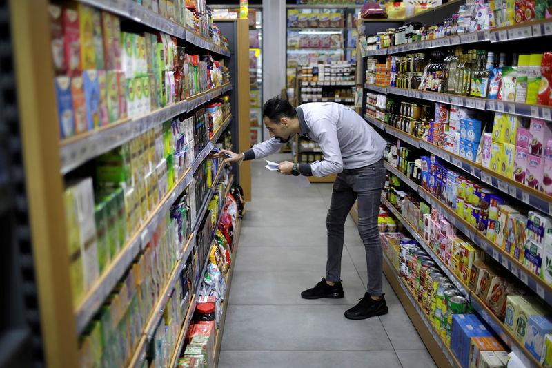© Reuters. A worker checks products inside a supermarket in Beirut