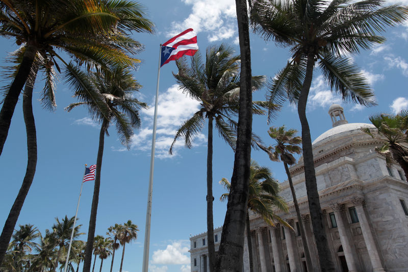 © Reuters. FILE PHOTO: The flags of the U.S. and Puerto Rico fly outside the Capitol building in San Juan