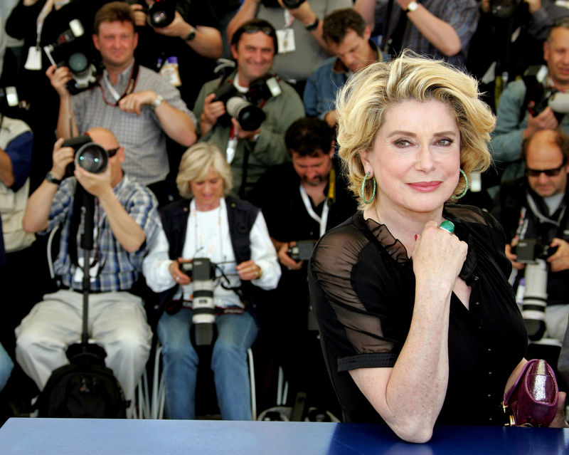 © Reuters. FILE PHOTO: French actress Catherine Deneuve smiles during a photo call at the 58th Cannes Film Festival May 12,..