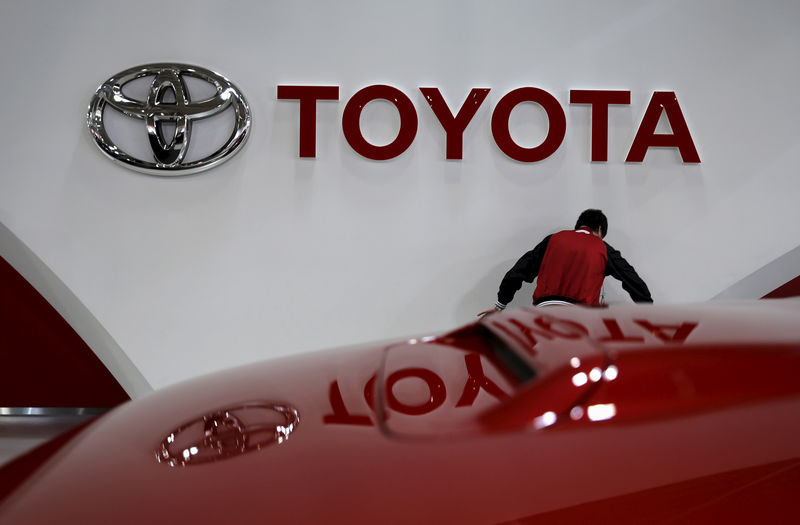 © Reuters. An employee works under a Toyota Motor Corp logo at the company's showroom in Tokyo