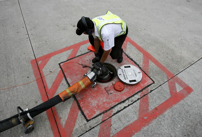 © Reuters. File photo of a technician attaching a jet fuel supply pipe to outlet in tarmac at Changi airport in Singapore