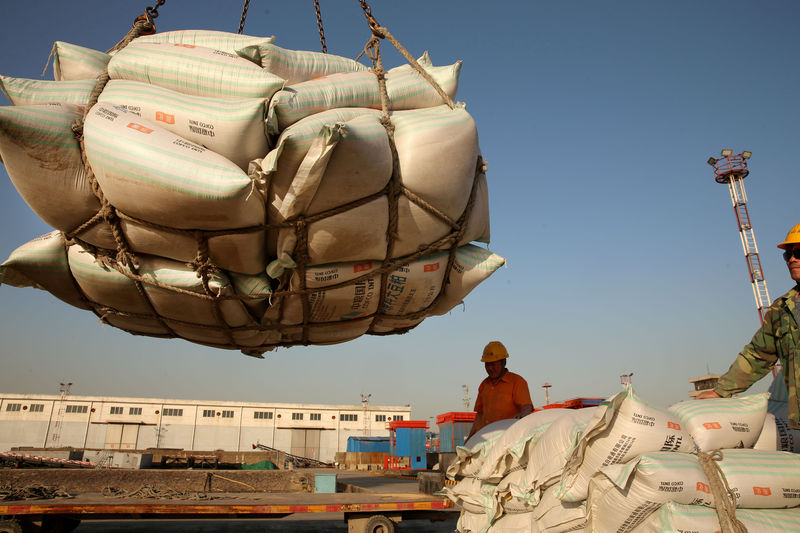 © Reuters. FILE PHOTO: Workers transport imported soybean products at a port in Nantong