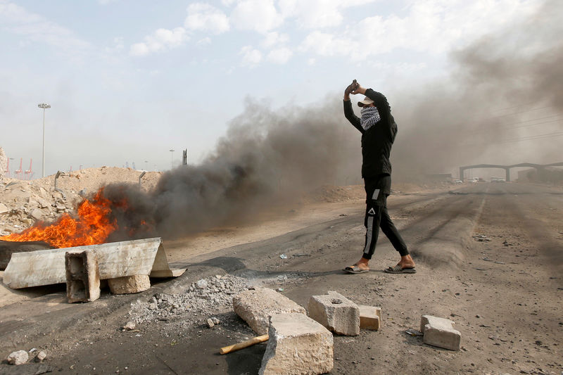 © Reuters. Iraqi protesters burn tires as they block the entrance to Umm Qasr Port, south of Basra