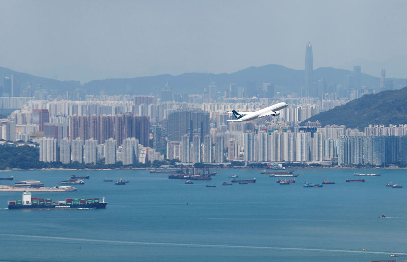 © Reuters. A Cathay Pacific flight flies over the city of Hong Kong