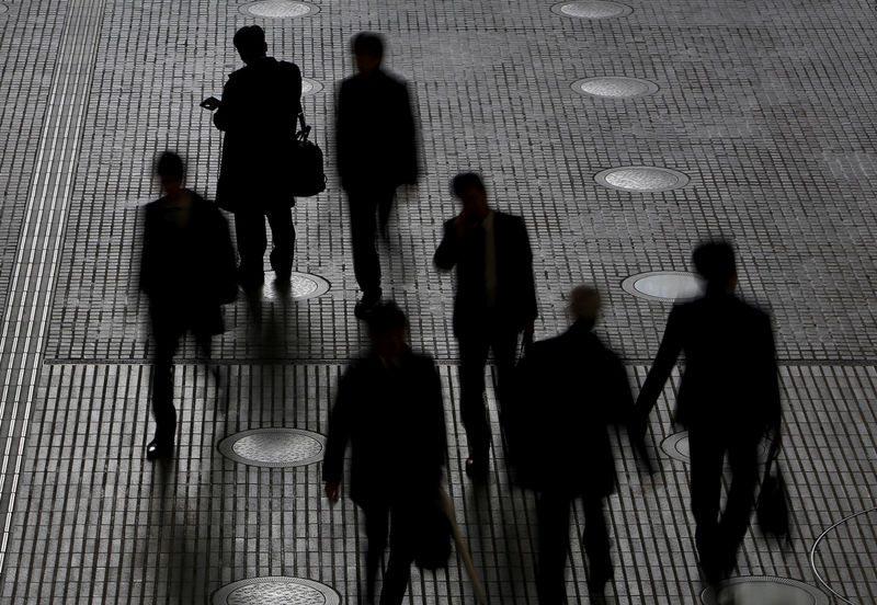© Reuters. FILE PHOTO: People walk at an office building at a business district in Tokyo