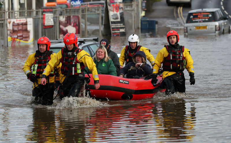 © Reuters. People are ferried to safety through the floodwaters in Rotherham