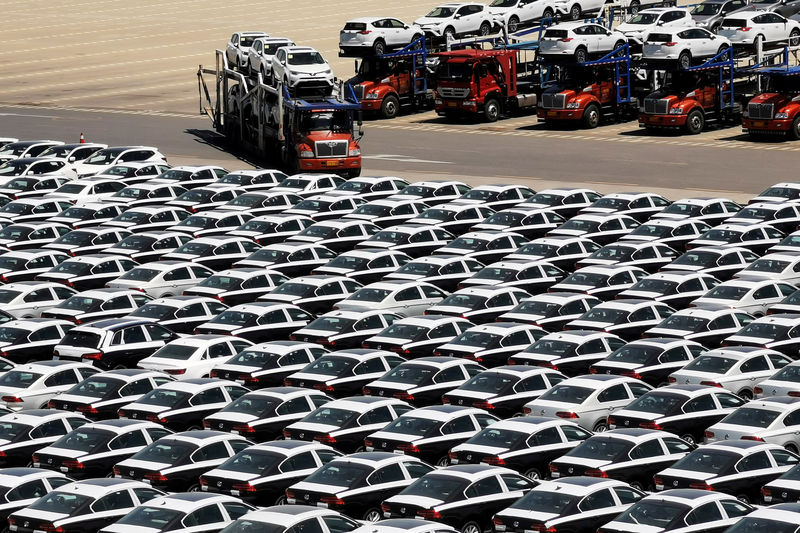 © Reuters. FILE PHOTO: Carrier trailer transports newly manufactured cars at a port in Dalian