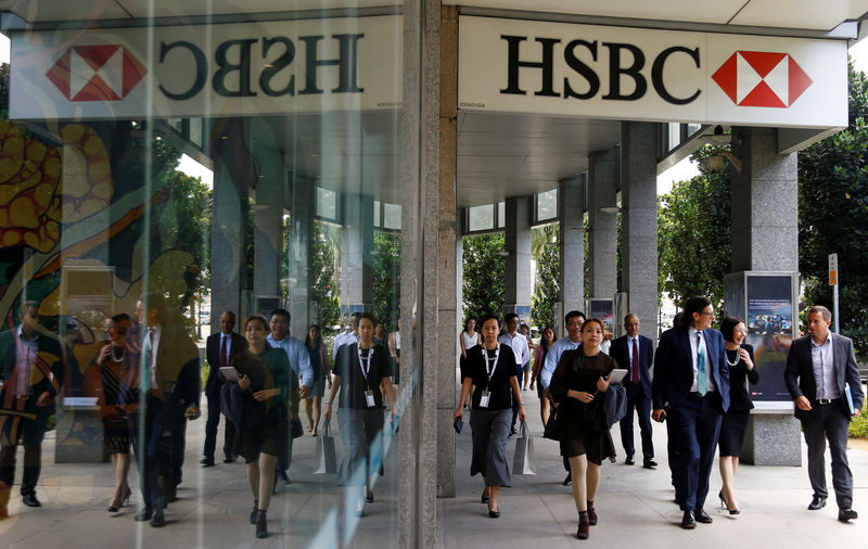 © Reuters. FILE PHOTO: People walk past a HSBC signage in Singapore