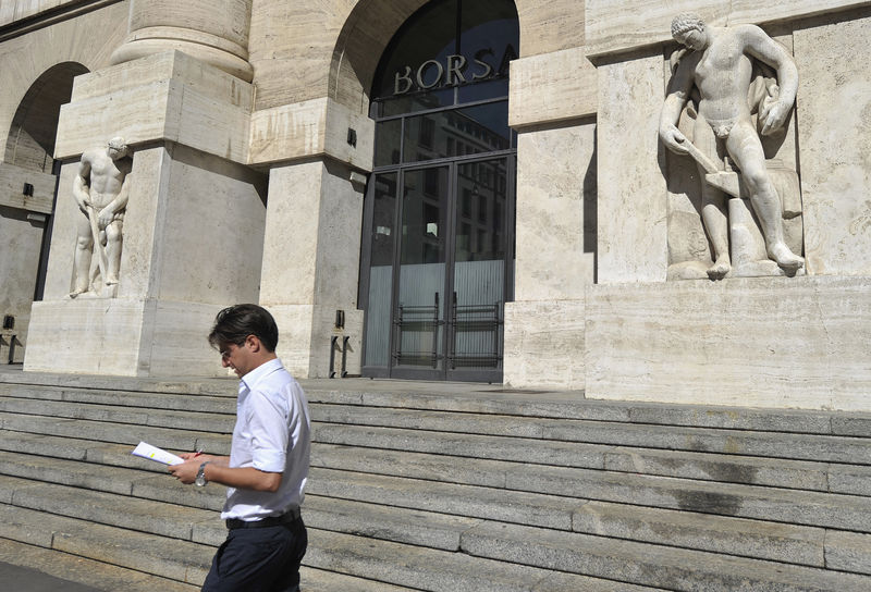 © Reuters. Un uomo fermo davanti alla Borsa di Milano