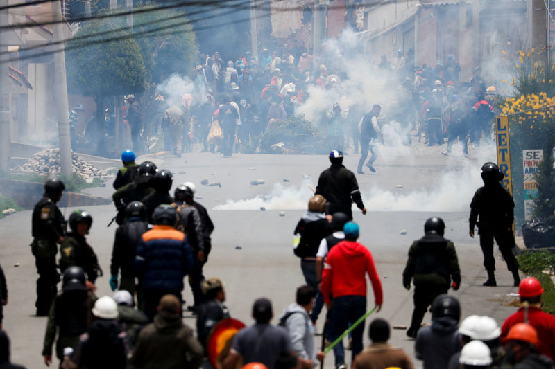 © Reuters. Supporters of Bolivian President Evo Morales and opposition supporters clash during a protest after Morales announced his resignation on Sunday, in La Paz