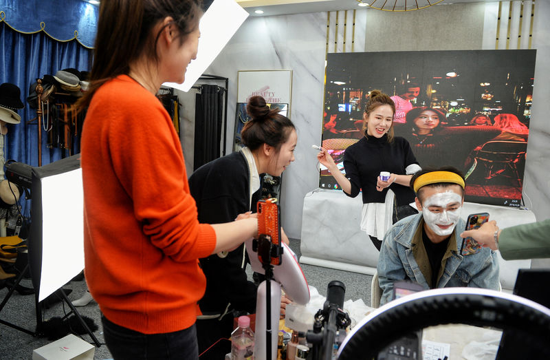 © Reuters. Live-streaming anchor and her assistant promote a facial mask through a live streaming session before the 11.11 Singles' Day shopping festival, at her studio in Hangzhou