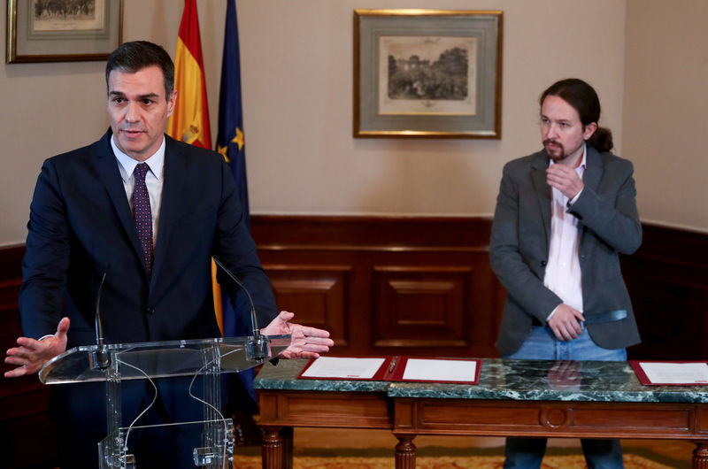 © Reuters. El presidente del gobierno en funciones de España, Pedro Sánchez, y el líder de Unidas Podemos, Pablo Iglesias, firman un acuerdo de coalición durante una conferencia de prensa en el Congreso de los Diputados en Madrid