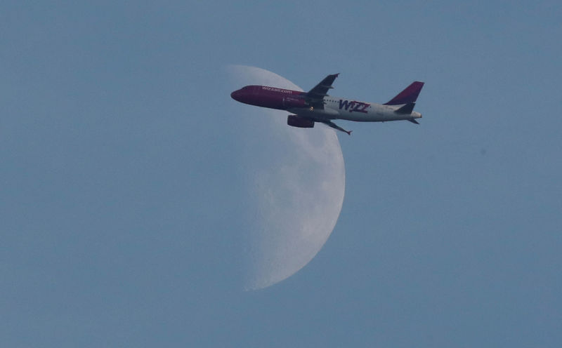 © Reuters. A Wizz Air passenger airplane flies past a Waxing Crescent moon, Harpenden