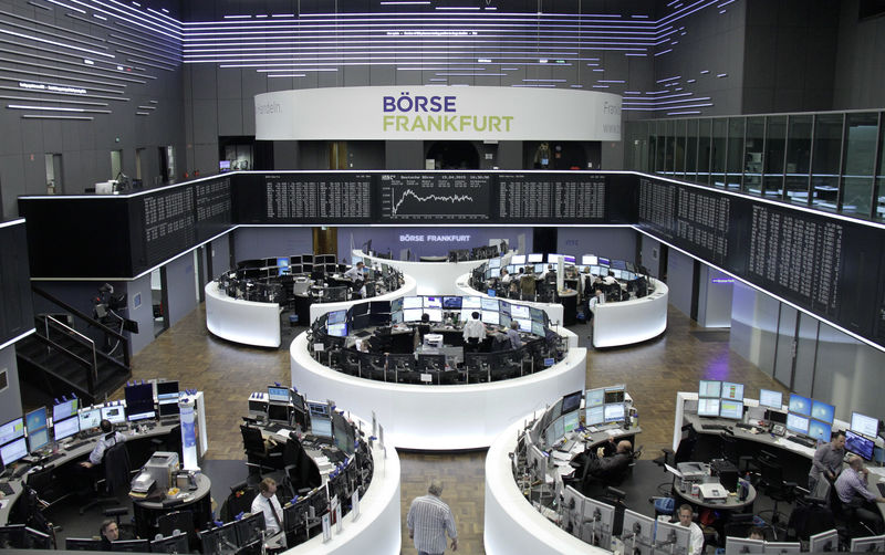 © Reuters. FILE PHOTO: Traders are pictured at their desks in front of the DAX board at the Frankfurt stock exchange