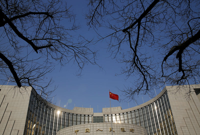 © Reuters. FOTO DE ARCHIVO: Una bandera nacional china ondea en la sede del Banco Popular de China, el banco central del país, en Beijing