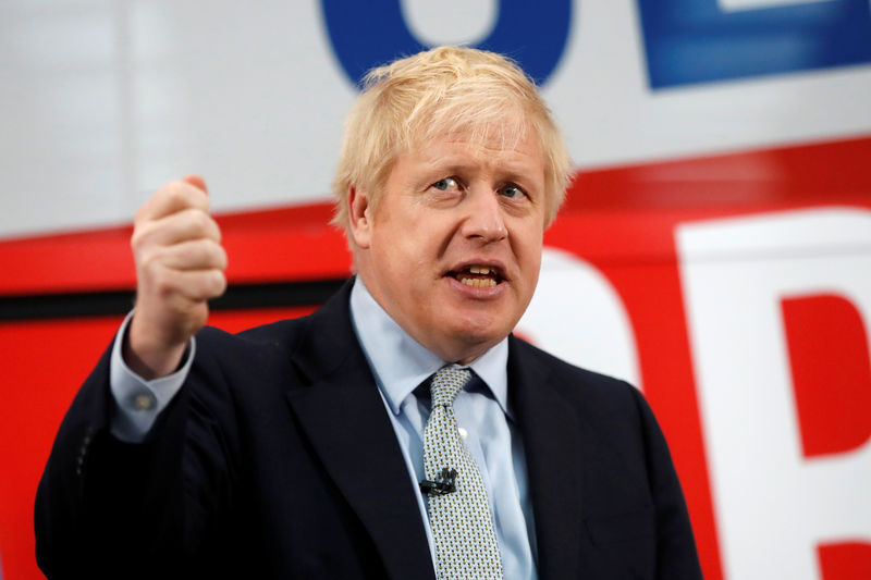 © Reuters. FILE PHOTO: Britain's Prime Minister Boris Johnson addresses his supporters in front of the general election campaign trail bus in Manchester