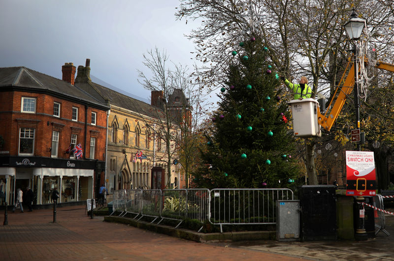 © Reuters. Council worker adds decorations to a Christmas tree in the town centre of Nantwich