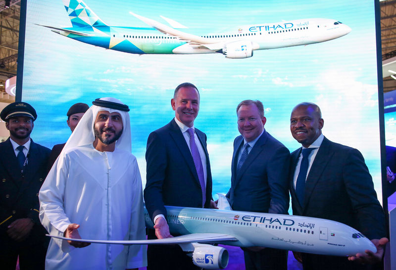 © Reuters. Etihad COO Mohammad Al-Bulooki, Etihad CEO Tony Douglas, Boeing Commercial Airplanes president, CEO Stanley A. Deal and Boeing Global Services President and CEO Ted Colbert pose for a photo in front of a Boeing 787 Dreamliner model at Dubai Air show, Dubai