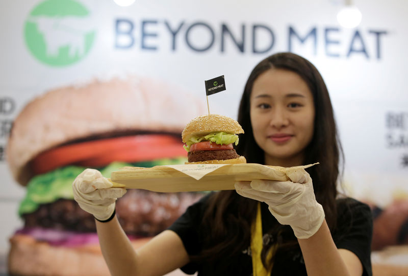 © Reuters. Staff member displays a burger with a Beyond Meat plant-based patty at VeggieWorld fair in Beijing