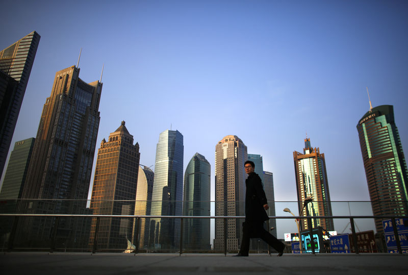 © Reuters. FILE PHOTO: A man walks at the financial district of Pudong in Shanghai