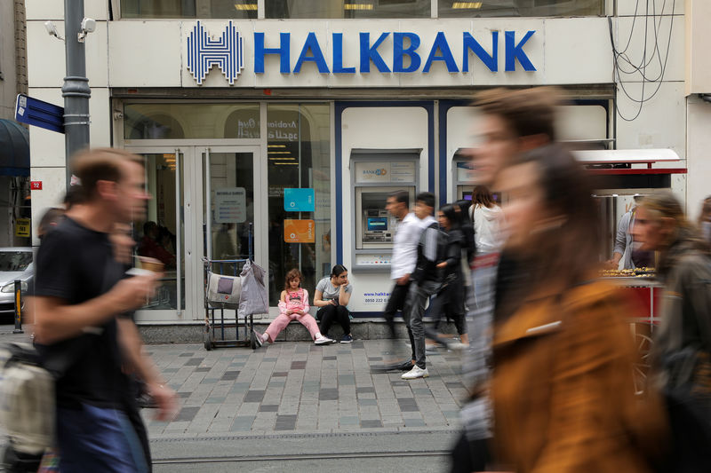 © Reuters. FILE PHOTO: People walk past by a branch of Halkbank in Istanbul