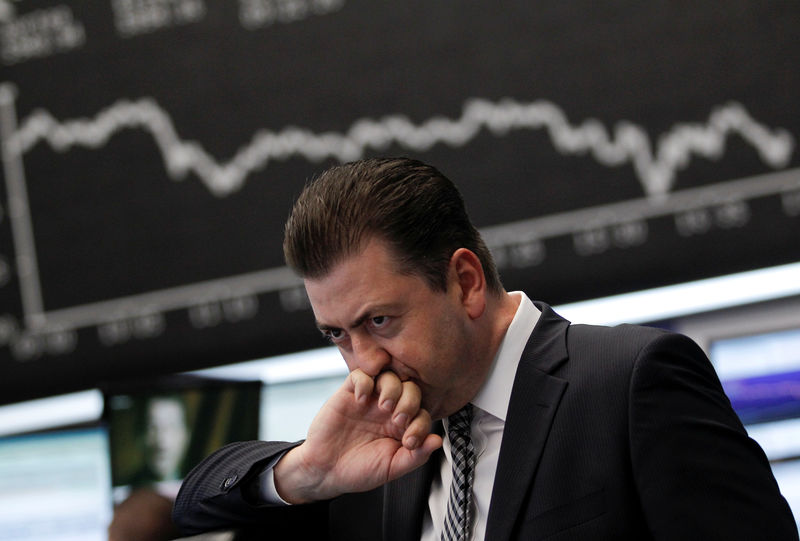 © Reuters. FILE PHOTO: Trader reacts at his desk in front of the DAX board at the Frankfurt stock exchange
