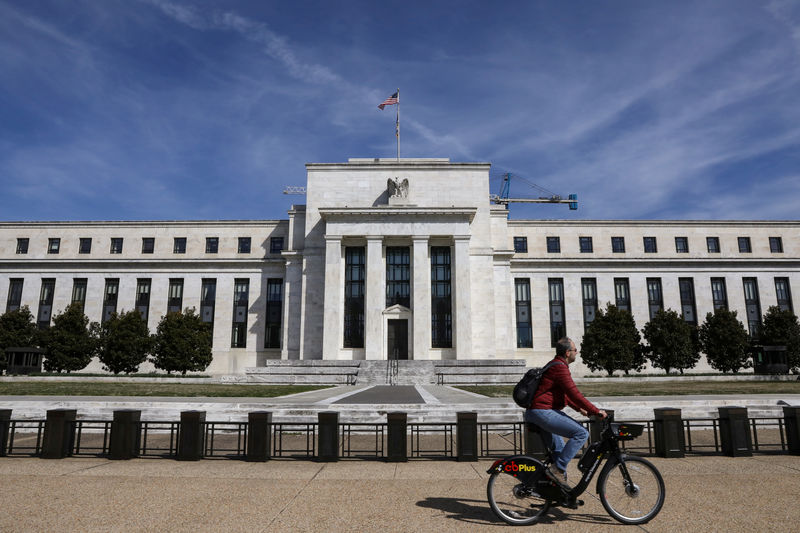 © Reuters. A man rides a bike in front of the Federal Reserve Board building on Constitution Avenue in Washington