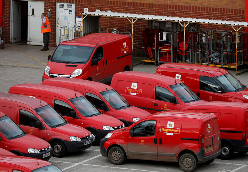 © Reuters. FILE PHOTO: A Royal Mail postal worker stands in the yard of a sorting office in Altrincham, Britain