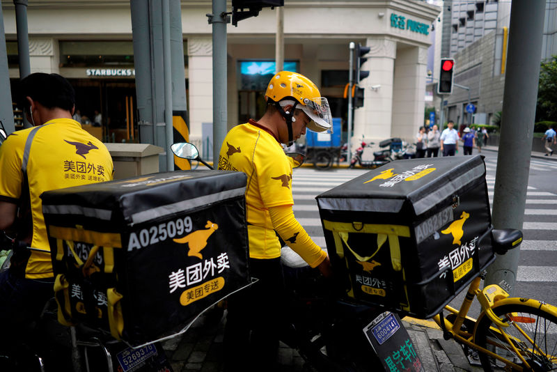 © Reuters. FILE PHOTO: Drivers of food delivery service Meituan are seen in Shanghai