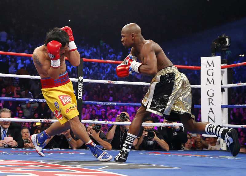 © Reuters. Mayweather, Jr. of the U.S. goes after Pacquiao of the Philippines in the first round during their welterweight title fight in Las Vegas