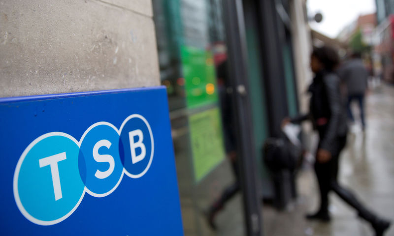 © Reuters. FILE PHOTO: A woman wlalks into a branch of TSB bank in London