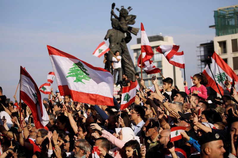 © Reuters. Attendees wave flags during a parade, on the 76th anniversary of Lebanon's independence, at Martyrs' Square in Beirut