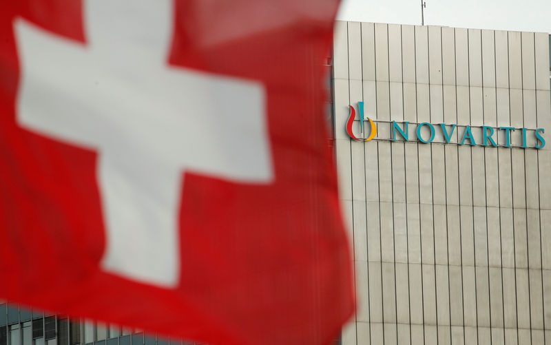 © Reuters. FILE PHOTO: Switzerland's national flag flies in front of the logo of Swiss drugmaker Novartis in Basel
