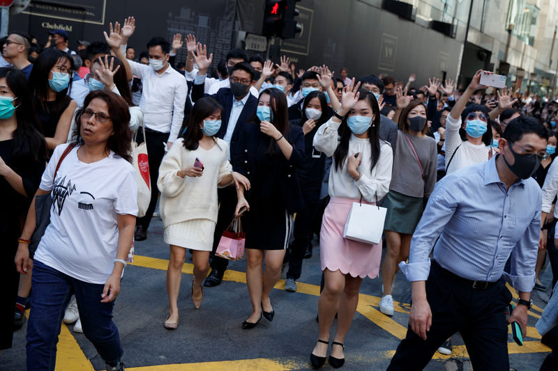 © Reuters. Office workers shout slogans as they attend a lunchtime anti-government protest in the Central district of Hong Kong