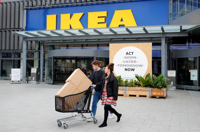 © Reuters. Customers walk by a placard reading "Act Now" as they leave the IKEA store in Kaarst