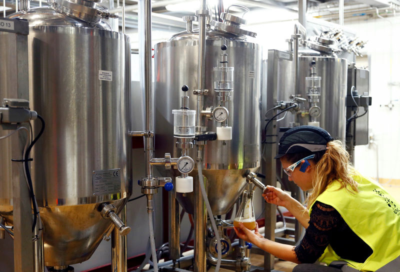 © Reuters. A worker checks beer quality at Anheuser-Busch InBev brewery in Leuven