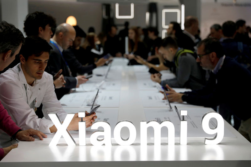 © Reuters. FILE PHOTO: Visitors visit the Xiaomi booth at the Mobile World Congress in Barcelona