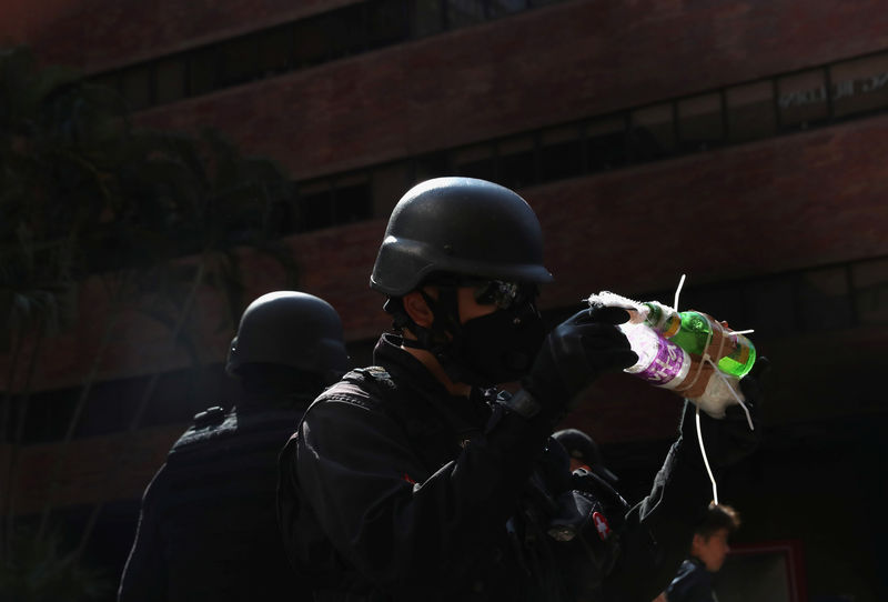 © Reuters. Los miembros de un equipo de seguridad establecido por la policía y las autoridades locales sostienen lo que se cree que es un cóctel molotov, en la Universidad Politécnica de Hong Kong (PolyU) en Hong Kong, China
