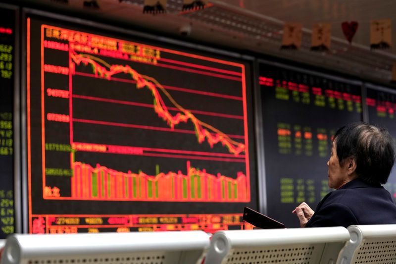 © Reuters. An investor watches a board showing stock information at a brokerage office in Beijing