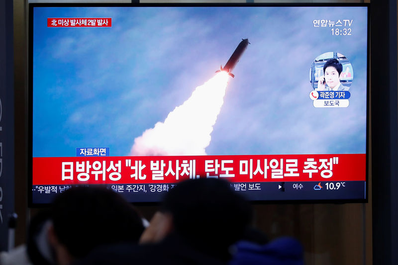 © Reuters. People watch a TV broadcasting file footage for a news report on North Korea firing an unidentified projectile, in Seoul