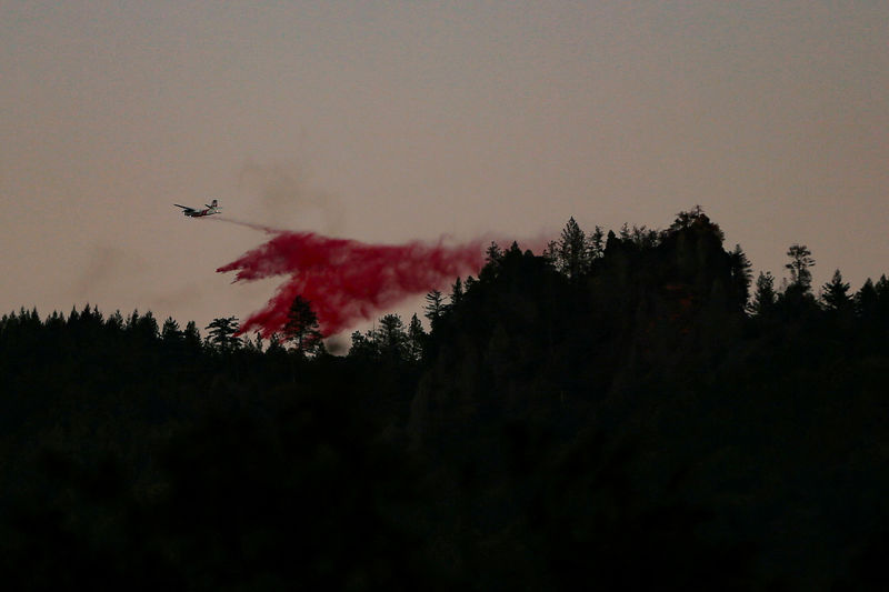 © Reuters. FILE PHOTO: An air tanker makes a retardant drop while battling the Kincade fire near Calistoga, California