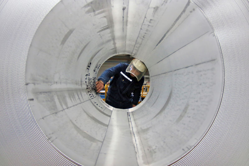 © Reuters. FILE PHOTO: Employee works at the production line of aluminium rolls at a factory in Zouping