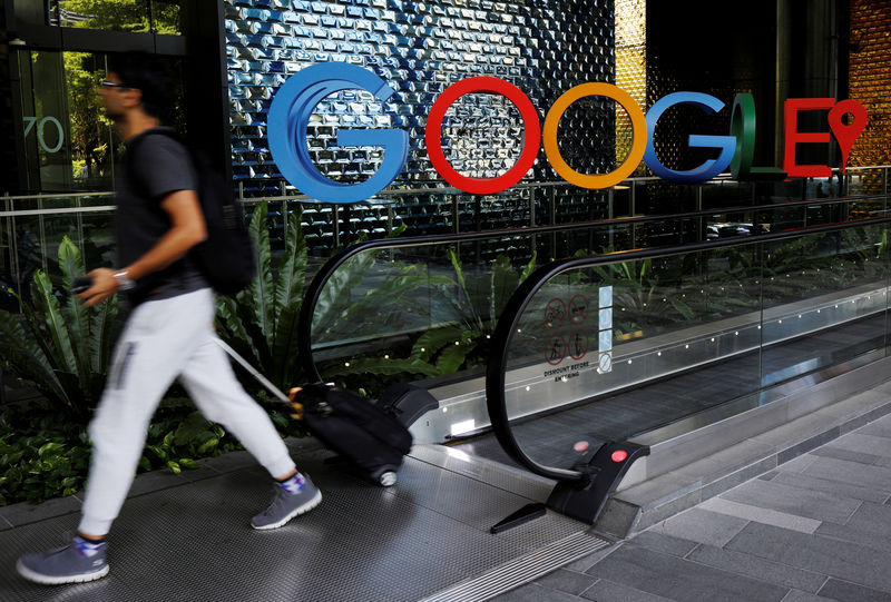 © Reuters. FILE PHOTO: A man passes a Google signage outside their office in Singapore