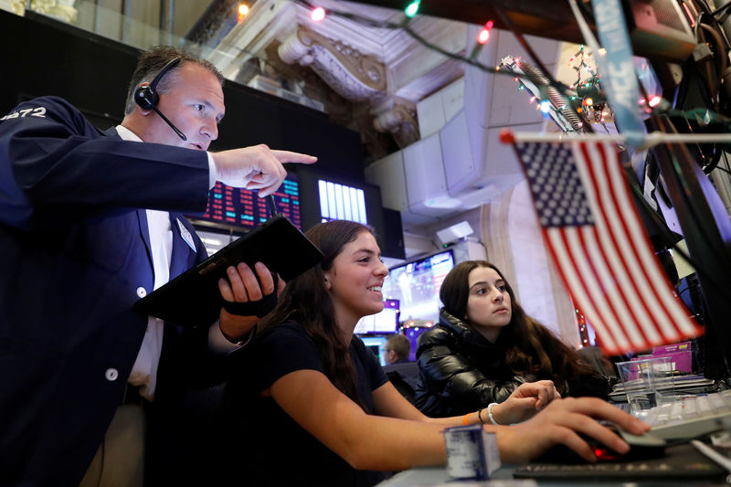 © Reuters. Trader Jonathan Corpina works with children during a traditional bring-your-kids-to-work day on the floor at the NYSE in New York
