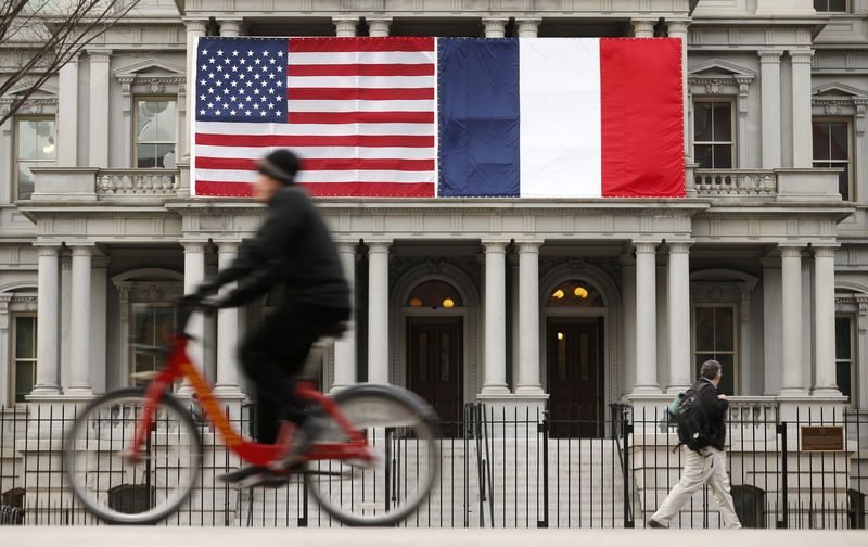 © Reuters. U.S. and French flags fly next to the White House to honor French President Hollande in Washington